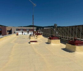 Nástřik PUR pěny kolem konstrukcí a antén na střeše BD. Nastříkaná plochá střecha PUR pěnou bytového domu po nástřiku v 5 cm připravená na silikonový nátěr.